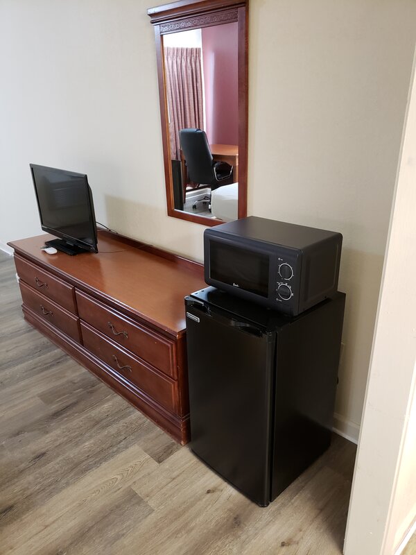 Image of a refrigerator and microwave in a room at the Travel Inn of Buford, in Buford Georgia.